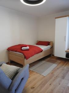 ForchtenbergEinzel- Monteurzimmer barrierfrei的一间卧室配有一张带红色床单的床和一把椅子