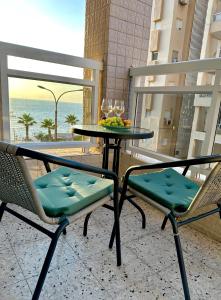 巴特亚姆Sea breeze的阳台上配有两把椅子和一张桌子及一碗水果