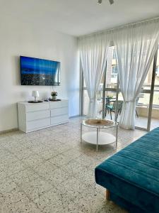 巴特亚姆Sea breeze的一间带床和电视的客厅