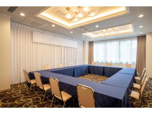三沢市Misawa City Hotel - Vacation STAY 81764v的一间大型会议室,配有蓝色的桌子和椅子