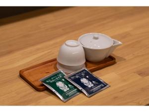 静冈Hotel Celeste Shizuoka Takajo - Vacation STAY 94099v的茶壶和木托盘上的书
