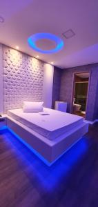 贝洛奥里藏特莫泰幻想3情趣酒店（仅限成人）的一间卧室配有一张蓝色灯光的大床
