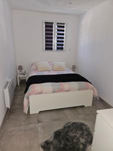 马赛Bas de villa au calme的白色的卧室设有床和窗户