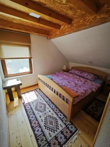 莫伊科瓦茨Mini Garden的一间卧室设有床、窗户和地毯。