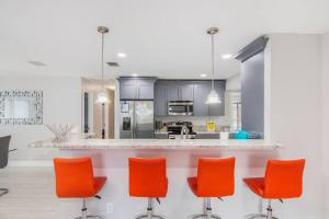 坦帕Y&M TAMPA SWEET HOME!的厨房配有橙色椅子和柜台