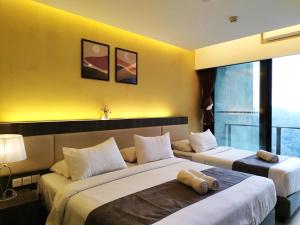 云顶高原GentingTop YinYangSuite6Pax @GrdIonDelmn的两张床位于带黄色墙壁的酒店客房