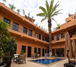马拉喀什Hotel Toulousain的棕榈树酒店和游泳池