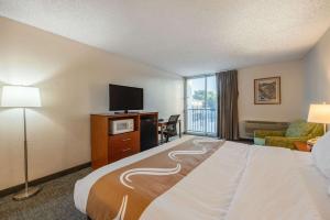 卡农城Quality Inn & Suites Canon City的配有一张床和一台平面电视的酒店客房