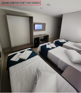 大坎普HOTEL CAMPO GRANDE的酒店客房设有两张床和一台平面电视。