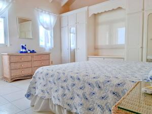 基督教堂市Beautiful Seaside 2BR Apartments的一间卧室配有一张床、梳妆台和窗户。