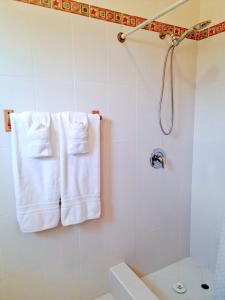 基督教堂市Beautiful Seaside 2BR Apartments的浴室设有悬挂在淋浴间的白色毛巾