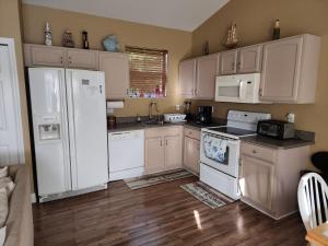 棕榈海岸Guest house withl kitchen living room 65" tv solar heated pool的铺有木地板的厨房配有白色家电