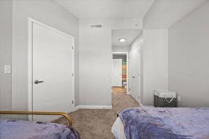盐湖城Charming Downtown Getaway的卧室拥有白色的墙壁,设有一张床和一扇门