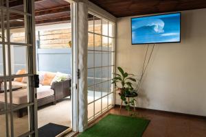 塔马林多Mai Ke Kai Surf House的客厅的墙上配有电视