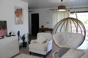 MatouryVilla Perle - 2 suites的客厅配有椅子和秋千