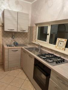 CeccanoAppartamento Marchesini的厨房配有炉灶和水槽