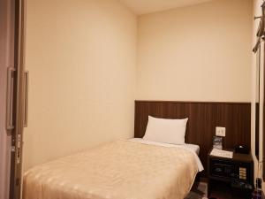 那霸Grand Cabin Hotel Naha Oroku for Men / Vacation STAY 62323的一间小卧室,配有一张床和电视