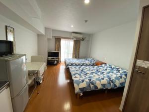 东京Takemura Building 3F的酒店客房设有两张床和电视。