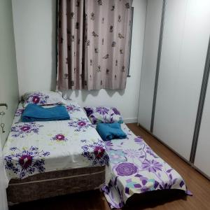 特雷索波利斯Apartamento em Teresópolis - RJ的一间卧室设有两张床和窗户。
