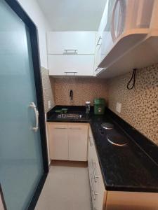 里约热内卢Loft em Olaria的小厨房配有白色橱柜和水槽
