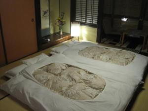 仓敷吉井日式旅馆的一张白色大床,上面有毛巾