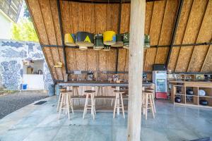 蓝梦岛Bong Hostel Nusa Lembongan的木墙建筑中带凳子的酒吧
