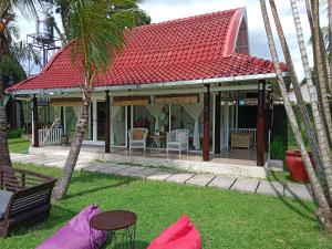 马塔兰Le Kekeri Villas Collection的一座红色屋顶的房子,还有一些棕榈树