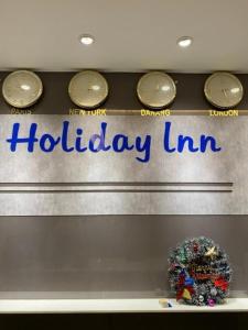 岘港Holiday Inn Hotel的假日旅馆标志的显示窗口,带时钟