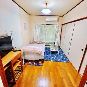 宫崎Shirahama Harbor的一间卧室配有一张床、一张书桌和一台电视