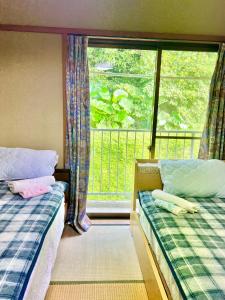 宫崎Shirahama Harbor的一间卧室设有两张床,窗户设有阳台