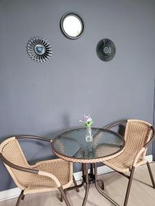 西归浦市PyoLi Guesthouse的一张带椅子的玻璃桌和一个花瓶