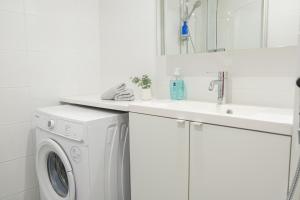 罗瓦涅米Snowflake Suites II的白色洗衣房配有水槽和洗衣机