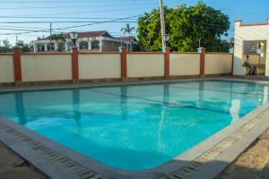 蒙巴萨Lux Suites Royal Family Apartment Nyali的 ⁇ 前的蓝色海水游泳池