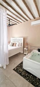 吉汶瓦ARYA Boutique Resort的一间卧室配有一张床和浴缸