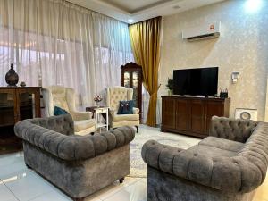 万挠Retreat Saujana rawang的客厅配有2张沙发和1台平面电视