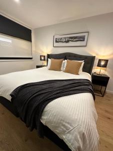 堪培拉Palko - Luxury In the City的卧室配有带棕色枕头的大型白色床