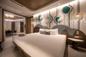 卡塔海滩Metadee Concept Hotel的一间带大床的卧室和一间餐厅