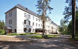 赫尔辛基Forenom Hostel Röykkä的前面有棵树的白色建筑