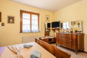 皮耶韦福斯切纳Casa di Nonna Adriana的一间卧室配有一张床、梳妆台和电视。