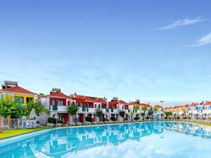 马斯帕洛马斯Bungalows Vistaflor的一座拥有多彩房屋的城市大型游泳池