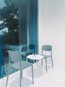 素攀武里TJ Garden & Resort的一间设有两把椅子、一张桌子和一个窗户的房间