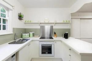 布赖特栗子树假日公寓的白色的厨房设有水槽和炉灶。