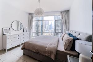 迪拜Heart of the Marina - 1 BR apartment的一间卧室设有一张床和一个大窗户