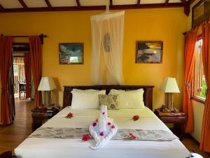 拉迪格岛拉迪格岛度假别墅酒店的一间卧室配有一张带鲜花的大床