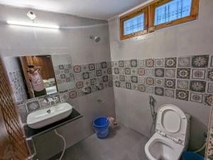 乌德尔格希Hotel KNB Heritage的画着带卫生间和水槽的浴室的人