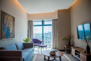 内罗毕Prime Living Luxury Apartments的客厅设有蓝色的沙发和大窗户