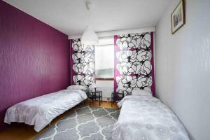 图尔库Saris 4 bedroom apartment with view的紫色墙壁和窗户的客房内的两张床