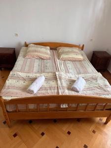 BagdatʼiMaximus Wine Cellar,Bagdati Wine House的一张木制床,上面有两个枕头