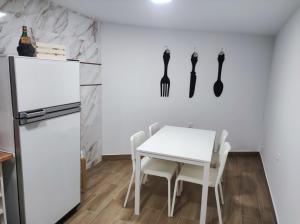 Rua da Avó的厨房配有白色桌子和白色冰箱。