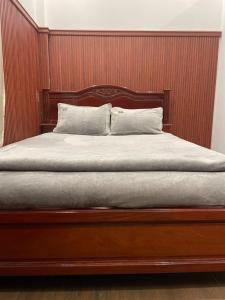 Long AnPhụng Kim Thảo Hotel Long An的一张带木制床头板和两个枕头的床